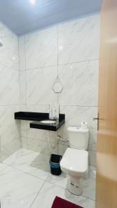 a white bathroom with a toilet and a sink at Hospedagens da Lucia in Pirenópolis +23 photos