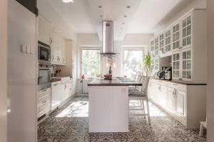 a kitchen with white cabinets and a island in it at C Apartments Annedal in Gothenburg