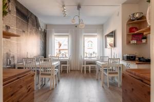 a kitchen with a dining room with white tables and chairs at C Apartments Annedal in Gothenburg