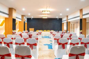 a conference room with white chairs and a stage at Clubway Grand A Boutique Hotel Jorhat in Jorhāt