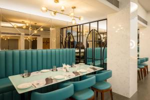 a dining room with a table and blue chairs at Clubway Grand A Boutique Hotel Jorhat in Jorhāt