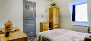 a bedroom with a bed and a blue door at Le Passage Secret in Saint-Omer