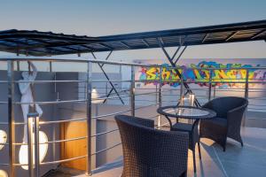 a balcony with chairs and tables on a ship at Clubway Grand A Boutique Hotel Jorhat in Jorhāt