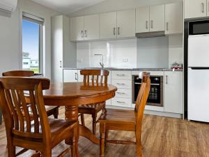 a kitchen with a wooden table and chairs and a refrigerator at Snapper Cabin in Portland