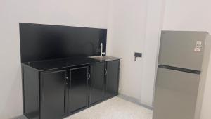 a kitchen with a sink and a refrigerator at Ck resort in Weligama