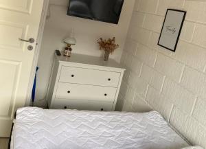 a bedroom with a bed and a dresser next to a wall at Cozy Cottage Close To The Beach in Bogense +4 photos