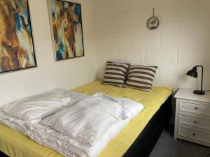a bed with a white comforter and pillows on it at Cozy Cottage Close To The Beach in Bogense