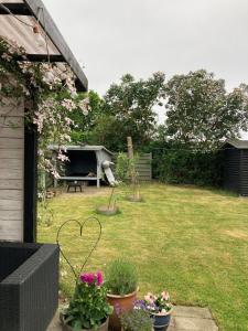 a backyard with a garden with a picnic table and flowers at Cozy Cottage Close To The Beach in Bogense