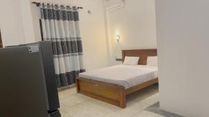 a bedroom with a bed and a refrigerator at Ck resort in Weligama +2 photos