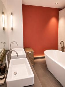 a bathroom with two sinks and a bath tub at Marienplatz Design Apartment - Historic Center in Munich