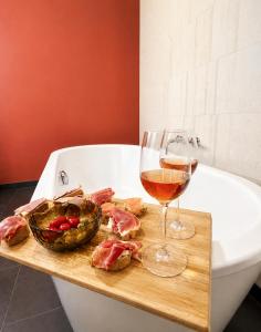 a glass of wine and a plate of meat on a cutting board at Marienplatz Design Apartment - Historic Center in Munich +10 photos