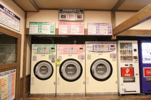 una fila di lavatrici in un negozio con cartelli di Hotel Hirayunomori Annex a Takayama