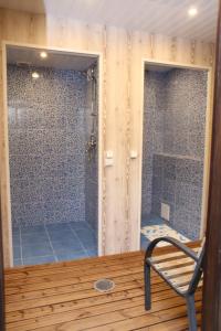 a bathroom with a shower and a chair in a room at Cottage Viardo in Vehkataipale
