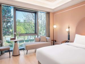 a bedroom with a bed and a large window at Mercure KunMing Airport in Kunming +60 photos