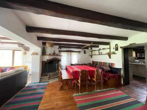 a living room with a red table and chairs at Къща за гости Младата Баба in Apriltsi