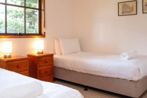 a bedroom with two beds and two lamps on night stands at Whalers Cottage in Port Fairy