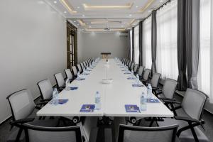 a large conference room with white tables and chairs at Beal Mall & Hotel in Arua