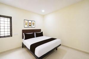 a bedroom with a bed in a white room at HOTEL O NAYARA in Hyderabad +20 photos