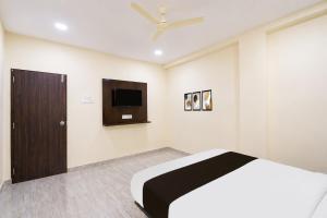 a bedroom with a bed and a tv on the wall at HOTEL O NAYARA in Hyderabad
