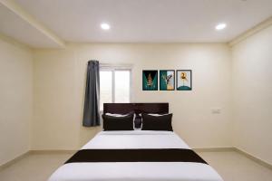 a bedroom with a large bed with black and white sheets at HOTEL O NAYARA in Hyderabad