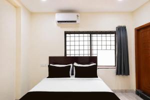 a bedroom with a bed and a window at HOTEL O NAYARA in Hyderabad