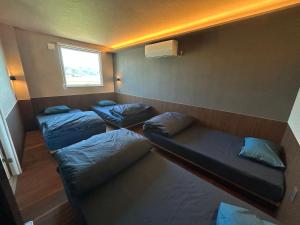 a room with three bunk beds and a window at Villa ORAN in Nakafurano