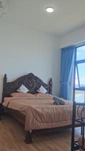 a bedroom with a large bed with a large window at Swiss belhotel apartment in Kuantan