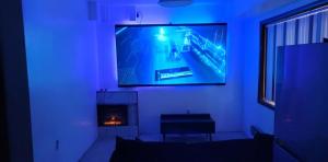 a living room with a tv on a wall with a fireplace at Anchorage Fireoved Home Theater Experience in Anchorage