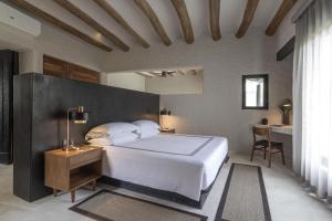 a bedroom with a large white bed and a desk at Thompson Zihuatanejo, A Beach Resort, by Hyatt in Zihuatanejo +83 photos