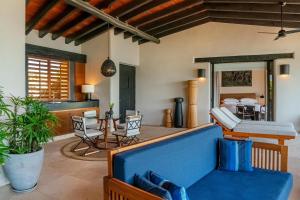 a living room with a blue couch and a table at Thompson Zihuatanejo, A Beach Resort, by Hyatt in Zihuatanejo