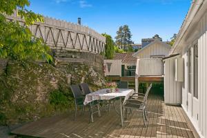 a table and chairs on a patio with a bridge at Hovedhuset in Kragerø