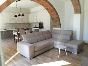 a living room with a couch and a kitchen at La terrazza di Isma in Ghizzano
