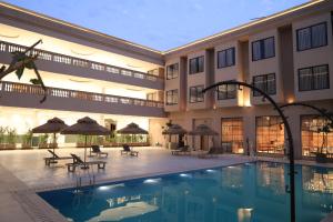 a hotel with a swimming pool in front of a building at Sai Krishna Hill View Resort in Pawārkhera