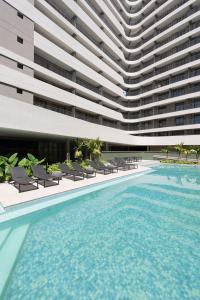 a swimming pool in front of a large building at Setin Downtown | Conforto no Centro de SP in São Paulo