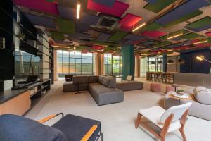 a large living room with a couch and a tv at Setin Downtown | Conforto no Centro de SP in São Paulo