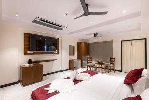 a bedroom with a large white bed and a table at Lumis Beach Hotel in Visakhapatnam