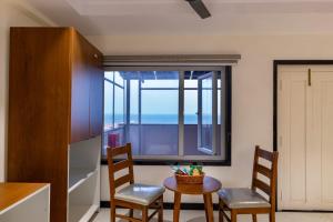 a kitchen with a table and two chairs and a window at Lumis Beach Hotel in Visakhapatnam
