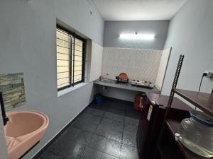 a bathroom with a sink and a window and a tub at Kenson Retreat in Mangalore