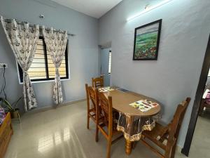 a dining room with a wooden table and chairs at Kenson Retreat in Mangalore +26 photos