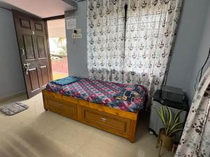 a small bed in a room with a window at Kenson Retreat in Mangalore