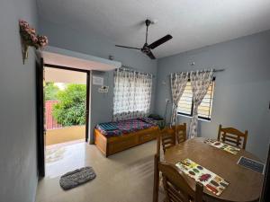 a dining room with a table and a bed and a table and chairs at Kenson Retreat in Mangalore