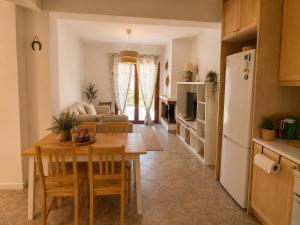 a kitchen and living room with a table and a refrigerator at Emma's HOUSE near beach in Tsakaíoi