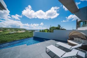 a view of a swimming pool from the patio of a house at Villa Azure Mira in Miyakojima