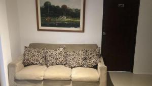a couch with pillows sitting in a living room at Luna habitaciones cama doble baño compartido parqueadero familiar o corporativos in Chía