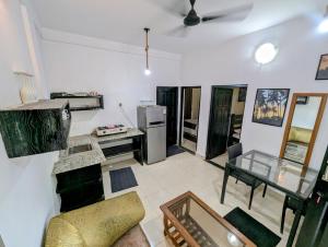ein Wohnzimmer mit Glastisch und Kühlschrank in der Unterkunft The Double V Experience in Arambol