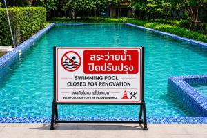 a swimming pool with a sign in front of it at Caesar's Suite Condo Korat - Pool Renovation in Ban Pra Dok