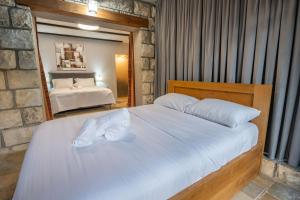 a bedroom with a large bed with white sheets at וילה ואמוס - Villa vamos - וילה מדהימה עם בריכה פרטית וג'קוזי in Rosh Pinna