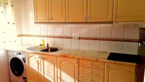 a kitchen with a sink and a washing machine at Apartamento Nora in Lagos