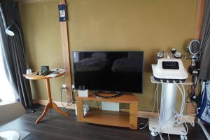 a room with a flat screen tv on a table at 結良house in Yura