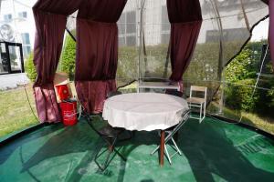 a room with a table and chairs in a greenhouse at 結良house in Yura